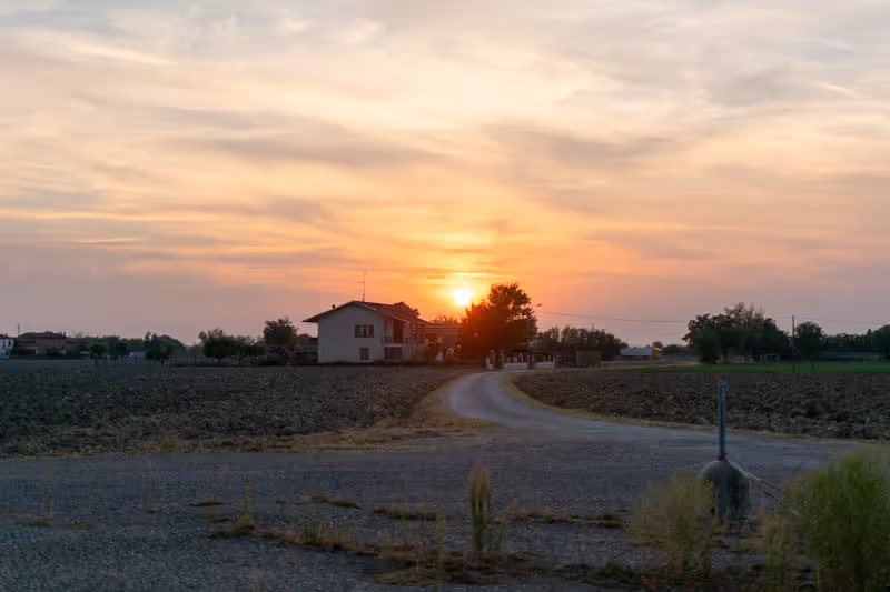 Cascina al tramonto tra i campi