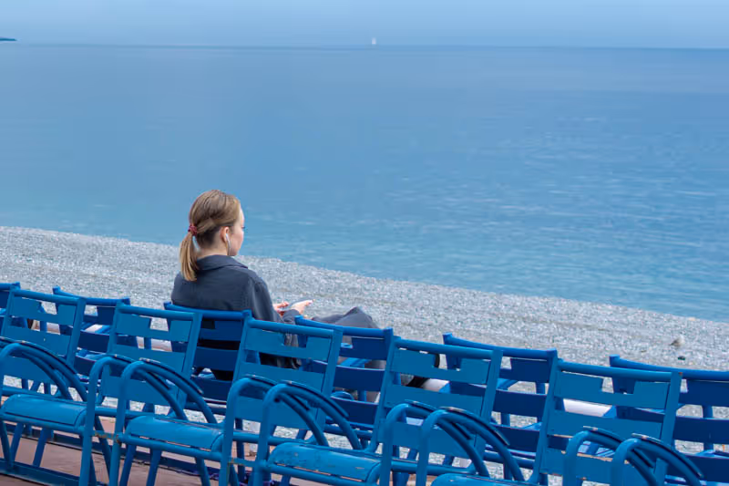 Persona seduta sulle sedie blu di Nizza