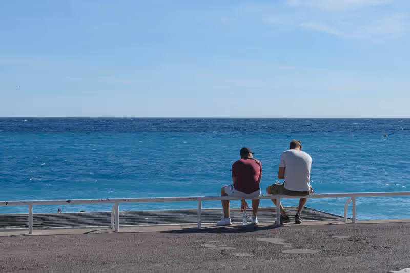 Due figure sedute davanti al mare